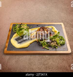 Saftige Schweinekoteletts mit Kartoffelpüree und grünem Salat Stockfoto