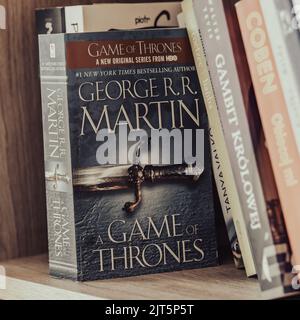 Ein Game of Thrones-Roman von George R.R. Martin auf einem hölzernen Bücherregal Stockfoto