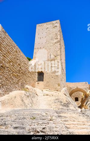 Niedrige Ansicht eines rechteckigen Turms. Architektonisches Merkmal aus Stein, das Teil des Entwurfs in der mittelalterlichen Militärfestung ist. Stockfoto