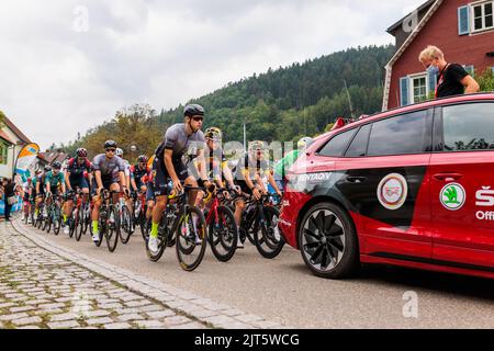 28. August 2022, Baden-Württemberg, Schiltach: Das Hauptfeld fährt mit der Tour von Deutschlands Sportdirektor Fabian Wegmann (r) hinter dem Auto. Die 4. und damit letzte Etappe der Deutschlandtour startet heute in Schiltach und endet in Stuttgart. Foto: Philipp von Ditfurth/dpa Stockfoto