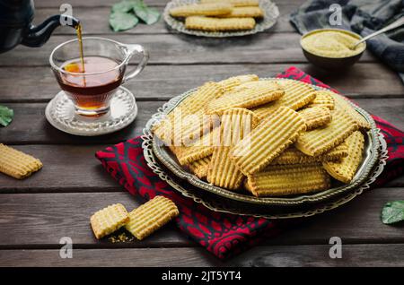 Cookies zur Feier des islamischen Festes El Fitr (das Fest, das nach dem Ramadan kommt).köstliche traditionelle Kekse mit einer Tasse Tee serviert. Stockfoto
