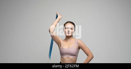 Brünette Frau mit einem Maßband. Athletische schlanke Frau, die ihren Körper nach einer Diät durch Maßband misst. Konzept der gesunden Ernährung und Ernährung. Stockfoto