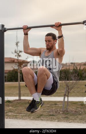 Ein junger Kaukasischer Sportlicher, der an einer Pull-up-Bar Sport macht Stockfoto