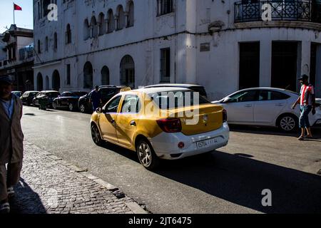 Tetouan, Marokko - 17. August 2022 Taxi fährt durch die Straßen von Tetouan während des Coronavirus-Ausbruchs trifft Marokko, trägt eine Maske ist mand Stockfoto