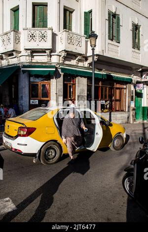 Tetouan, Marokko - 17. August 2022 Taxi fährt durch die Straßen von Tetouan während des Coronavirus-Ausbruchs trifft Marokko, trägt eine Maske ist mand Stockfoto