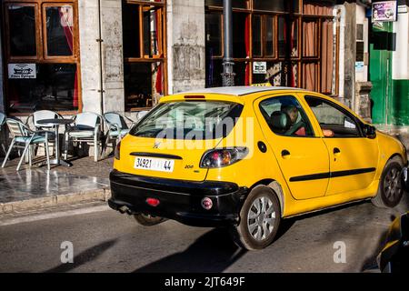 Tetouan, Marokko - 17. August 2022 Taxi fährt durch die Straßen von Tetouan während des Coronavirus-Ausbruchs trifft Marokko, trägt eine Maske ist mand Stockfoto