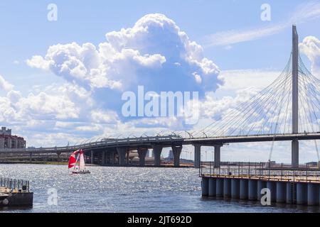 Segelboot mit roten Segeln und Yacht Bridge in St. Petersburg am Himmel mit Wolken Hintergrund, Kopierraum, selektiver Fokus. Sommersport und Wasseraktivitäten Stockfoto