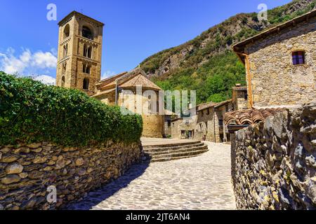 Enge Gasse aus Stein, die zum Stadtplatz führt, wo die Kirche ist, beget, Girona. Stockfoto