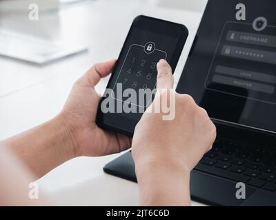 Zwei Schritte Authentifizierung oder 2FA Konzept. Nummern Passcode, Schlosscode-Symbol auf dem Smartphone-Bildschirm in der Hand mit Laptop zur Validierung Passwort-Seite, Stockfoto