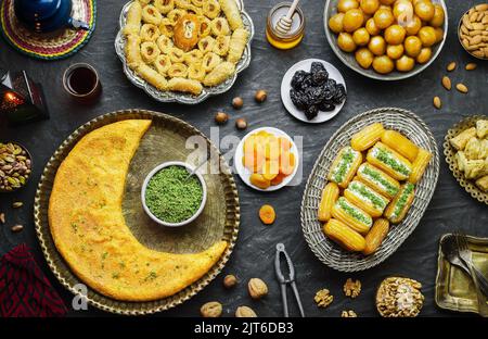 Arabische Küche: Desserts aus dem Nahen Osten. Köstliche Sammlung von traditionellen Ramadan Desserts. Serviert mit leckeren Nüssen, getrockneten Früchten und Honigsirup. Stockfoto