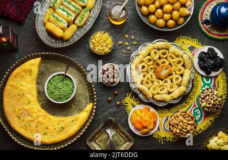 Arabische Küche: Desserts aus dem Nahen Osten. Köstliche Sammlung von traditionellen Ramadan Desserts. Serviert mit leckeren Nüssen, getrockneten Früchten und Honigsirup. Stockfoto