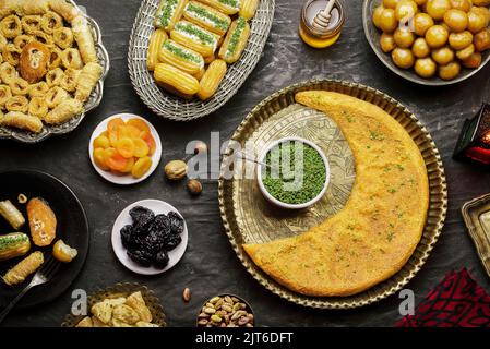 Arabische Küche: Desserts aus dem Nahen Osten. Köstliche Sammlung von traditionellen Ramadan Desserts. Serviert mit leckeren Nüssen, getrockneten Früchten und Honigsirup. Stockfoto