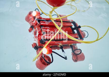 Hintergrundbild oder rotes Roboter-U-Boot im Wasserbehälter im Ingenieurswesen und Robotik-Klassenzimmer, Kopierraum Stockfoto