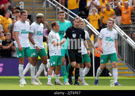 Wolverhampton, England, 28.. August 2022. Die Spieler von Newcastle United beschweren sich beim Schiedsrichter Peter Barnes über das zweite Wolves-Tor während des Premier League-Spiels in Molineux, Wolverhampton. Bildnachweis sollte lauten: Andrew Yates / Sportimage Stockfoto
