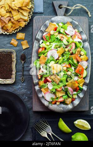 Arabische Küche; traditioneller Salat aus dem Nahen Osten. Köstlicher Fattoush-Salat mit frischen Tomaten, Gurken, Petersilie, Minze, Rettich, Salat und Pita Croutons Stockfoto