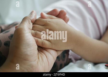 Vater hält die Hand des Kindes in der Nähe Stockfoto