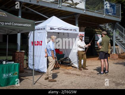 Ein Mann zeigt potenziellen Kunden eine Schrotflinte im Southdown Gun Club in Findon, West Sussex, Großbritannien. Stockfoto