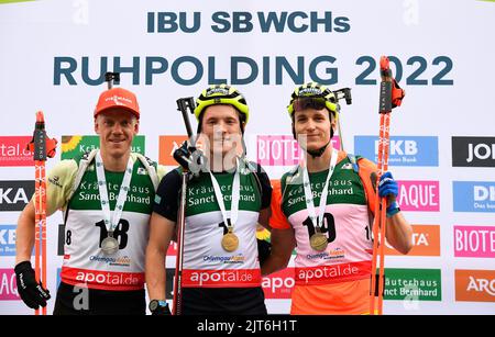 Ruhpolding, Deutschland. 28. August 2022. Biathlon, Sommer-Weltmeisterschaften, Massenstart, Männer: Roman Rees (Deutschland, l-r), Sieger Sebastian Samuelsson (Schweden) und Martin Ponsiluoma (Schweden), der dritte, stehen nach dem Massenstartrennen der Männer während der Biathlon-Sommer-Weltmeisterschaften auf dem Podium. Quelle: Uwe Lein/dpa/Alamy Live News Stockfoto