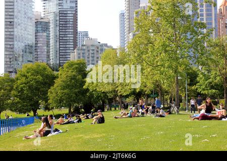Mehrere Menschen entspannen sich an einem sonnigen Tag im Zentrum von Vancouver, British Columbia, Kanada Stockfoto