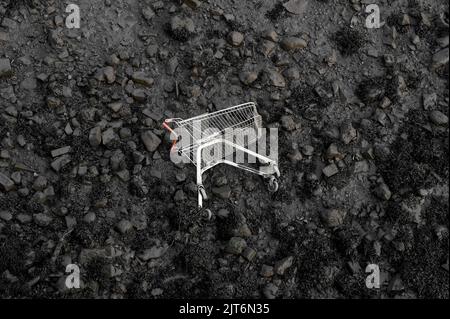 Trolley-Wagen, der am verschmutzten Strand aufgegeben wurde Stockfoto