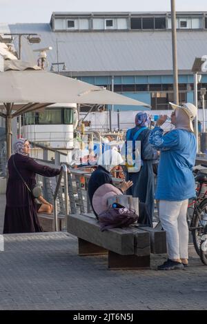 Vier arabische Frauen tragen Hijab-Ruhepausen im Hafen von Jaffa, Israel. Stockfoto