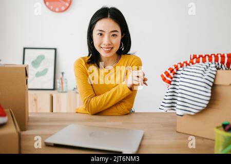 Porträt des jungen asiatischen Kleinunternehmers am Ladenarbeitsplatz Stockfoto