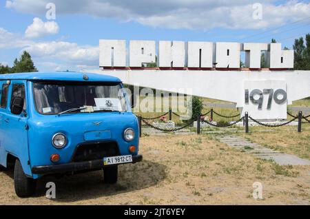 Blauer Van hielt vor dem Willkommensschild Prypiat, Tschernobyl-Sperrzone, Ukraine Stockfoto