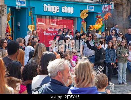 Edinburgh, Großbritannien. 28. August 2022. Edfringe vorletzter Tag, Edinburgh, Schottland, Großbritannien. Am zweitletzten Tag des Edinburgh Festival Fringe ist immer noch viel los um die High Street und den Mound. Temperatur 19 Grad Celsius. Unterhaltsam durch Jonglieren des Feuers. Kredit: ArchWhite/alamy Live Nachrichten. Quelle: Arch White/Alamy Live News Stockfoto