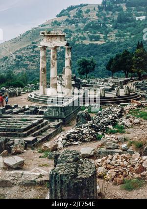 März 1980. Archivscan von einem Dia. Blick auf den Tholos von Delphi (kreisförmige Kuppel) auf das Heiligtum der Athene Pronaea. Delphi, antike Stadt und Sitz des wichtigsten griechischen Tempels und orakels von Apollo im Gebiet von Phocis auf dem steilen unteren Hang des Berges Parnassus, etwa 6 Meilen (10 km) vom Golf von Korinth entfernt. Delphi ist heute eine bedeutende archäologische Stätte mit gut erhaltenen Ruinen. Stockfoto