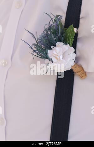 Bräutigam im weißen Hemd mit Boutonniere. Blumenmuster, Floristik. Hochzeitstag und Zubehör, Platz zum Kopieren. Stockfoto