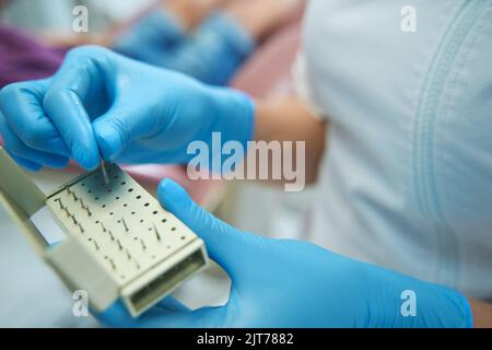 Ein erfahrener Stomatologe wählt Werkzeuge für die Vorbereitung der Kavität aus Stockfoto