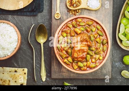 Okra-Eintopf mit einem Stück Rindfleisch und serviert mit weißem Reis, frischem Pitabrot und Zitrone. Es ist ein traditionelles ägyptisches, griechisches, türkisches und rumänisches Gericht. Stockfoto