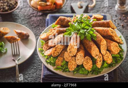 Arabische Küche; traditionelle ägyptische Küche 'Mombar'. Es ist Rinderwurst gefüllt mit Reiskörner, Hackfleisch und frittiert in Öl. Stockfoto