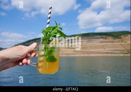 Frau Hand mit Limonade vor einer rheinlandschaft im Sommer Stockfoto