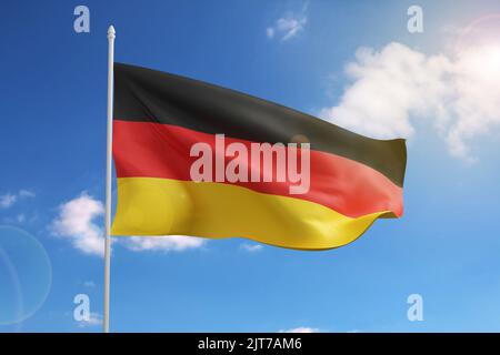 Flagge Deutschlands auf blauem Himmel. 3D Abbildung. Stockfoto