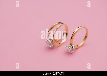 Hochzeit und Diamantringe auf hellrosa Hintergrund Stockfoto