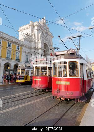 Trams alias Streetcar alias Trolleys in Pracala do Comércio (Handelsplatz) Lissabon, Portugal. Arco da Rua Augusta Arch links Stockfoto