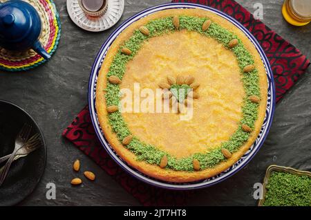 Arabische Küche: Traditionelles Gebäck aus dem Nahen Osten und das berühmte Dessert „Kunafa“ im Ramadan mit zerdrückten Pistazien und gerösteten Mandeln. Stockfoto