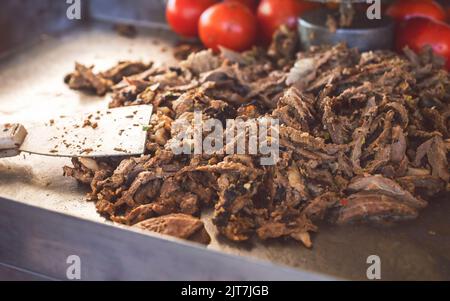 Arabische Küche; leckere dünne Schnitte mit gewürztem Fleisch. Nahaufnahme der traditionellen „Shawarma“ aus dem Nahen Osten, die aus marinierten Fleischscheiben besteht. Stockfoto