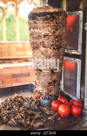 Arabische Küche; köstliche gegrillte, gegrillte Shawarma am Spieß. Traditionelle arabische Gerichte, die aus dünnen, gewürzten, marinierten Kalbfleisch- oder Rindfleischstücken zubereitet werden. Stockfoto