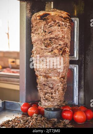 Arabische Küche; köstliche gegrillte, gegrillte Shawarma am Spieß. Traditionelle arabische Gerichte, die aus dünnen, gewürzten, marinierten Kalbfleisch- oder Rindfleischstücken zubereitet werden. Stockfoto