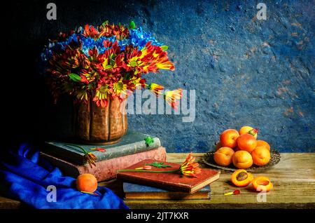 Klassisches Stillleben mit Blumen aus Gänseblümchen und Decke, die in Kupfervase auf alten Büchern, Schal, Aprikosen auf rustikalem Holzhintergrund platziert sind. Stockfoto