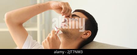 Junger Mann mit Nasenblut zu Hause Stockfoto