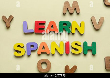 Text SPANISCH LERNEN mit Buchstaben auf beigem Hintergrund Stockfoto
