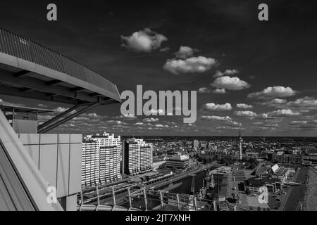 Eine Graustufenaufnahme eines Stadtbildes und eines Flusses unter bewölktem Himmel von einem hohen Turm aus Stockfoto