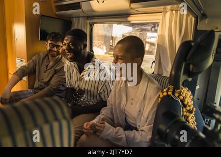 Multirassische Freunde, die Spaß im Van haben, mittelgeschossiges Reisen und Freundschaftskonzept. Hochwertige Fotos Stockfoto