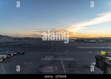 Der Sonnenaufgang aus dem Fenster des Gebäudes des San Francisco International Airport, Stockfoto