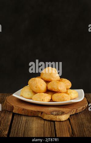 Gougeres auf weißem Teller auf Holzhintergrund mit Platz Stockfoto