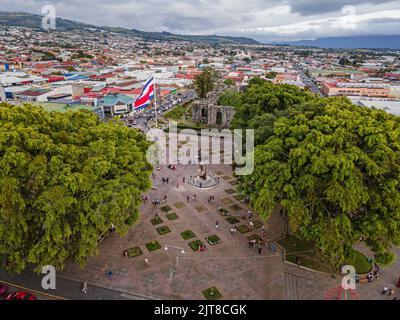 Wunderschöne filmische Luftaufnahmen der Ruinen, der Costarican-Flagge und des zweihundertjährigen Denkmals im Cartago Center in Costa Rica Stockfoto