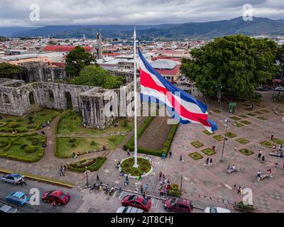 Wunderschöne filmische Luftaufnahmen der Ruinen, der Costarican-Flagge und des zweihundertjährigen Denkmals im Cartago Center in Costa Rica Stockfoto